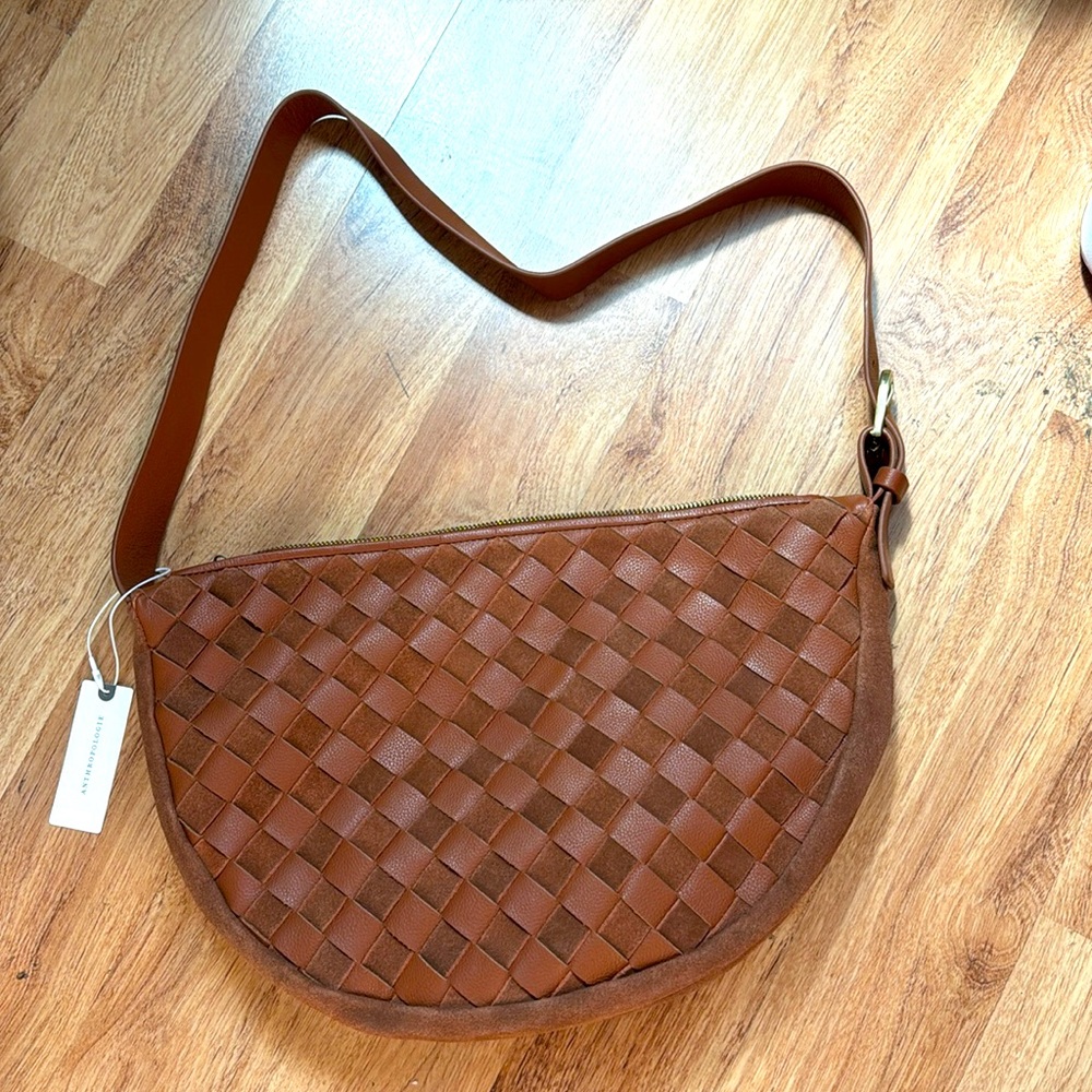 Anthropologie brand tan woven sling handbag.